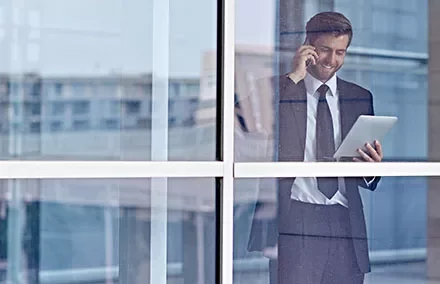 Persona in ufficio con tablet e telefono.