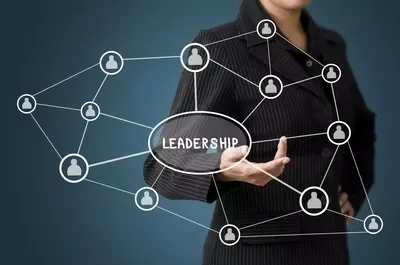 Persona in abito nero con diagramma di leadership interconnesso.