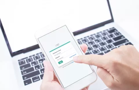 Persona utilizza un cellulare per accedere a un account.