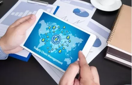 Persona tiene tablet con schermo di gestione della catena di fornitura.