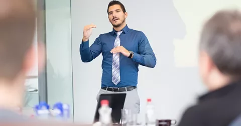Persona che parla durante una presentazione in ufficio.