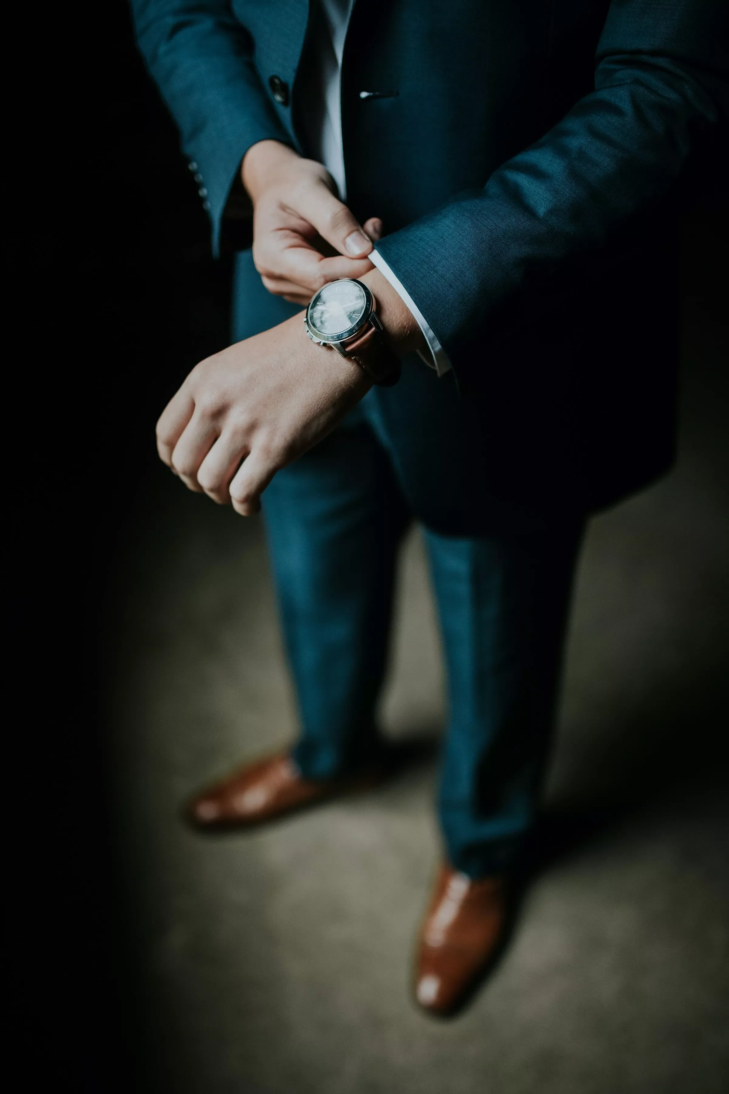 Persona in abito elegante controlla l'orologio.