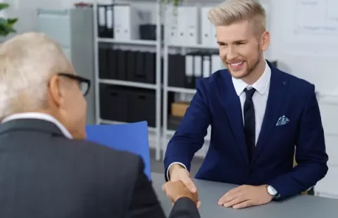 Colloquio di lavoro, stretta di mano tra due persone.